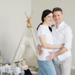 A joyful family with a toddler in a cozy room with playful decor and a teepee.